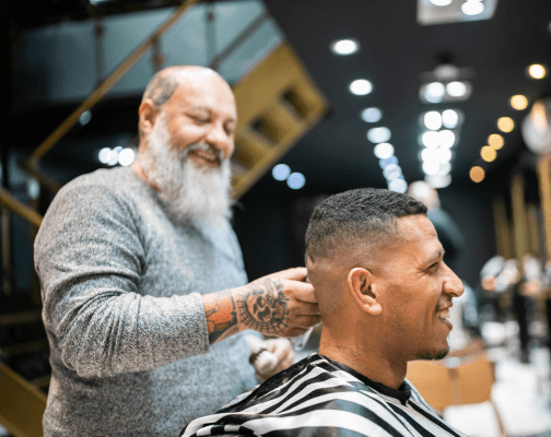 A modern barbershop with a barber attending to a client.