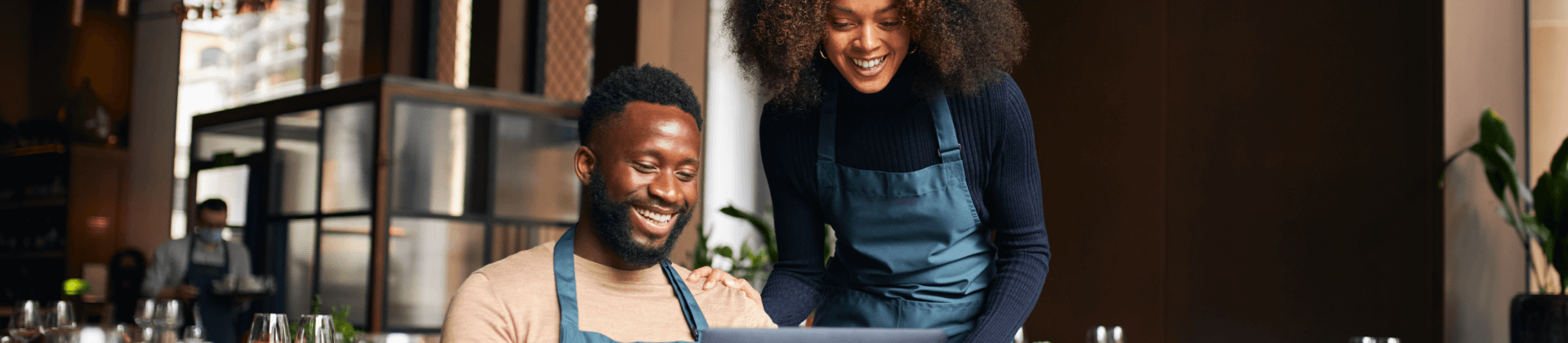 Smiling Restaurant Owners Looking at Laptop